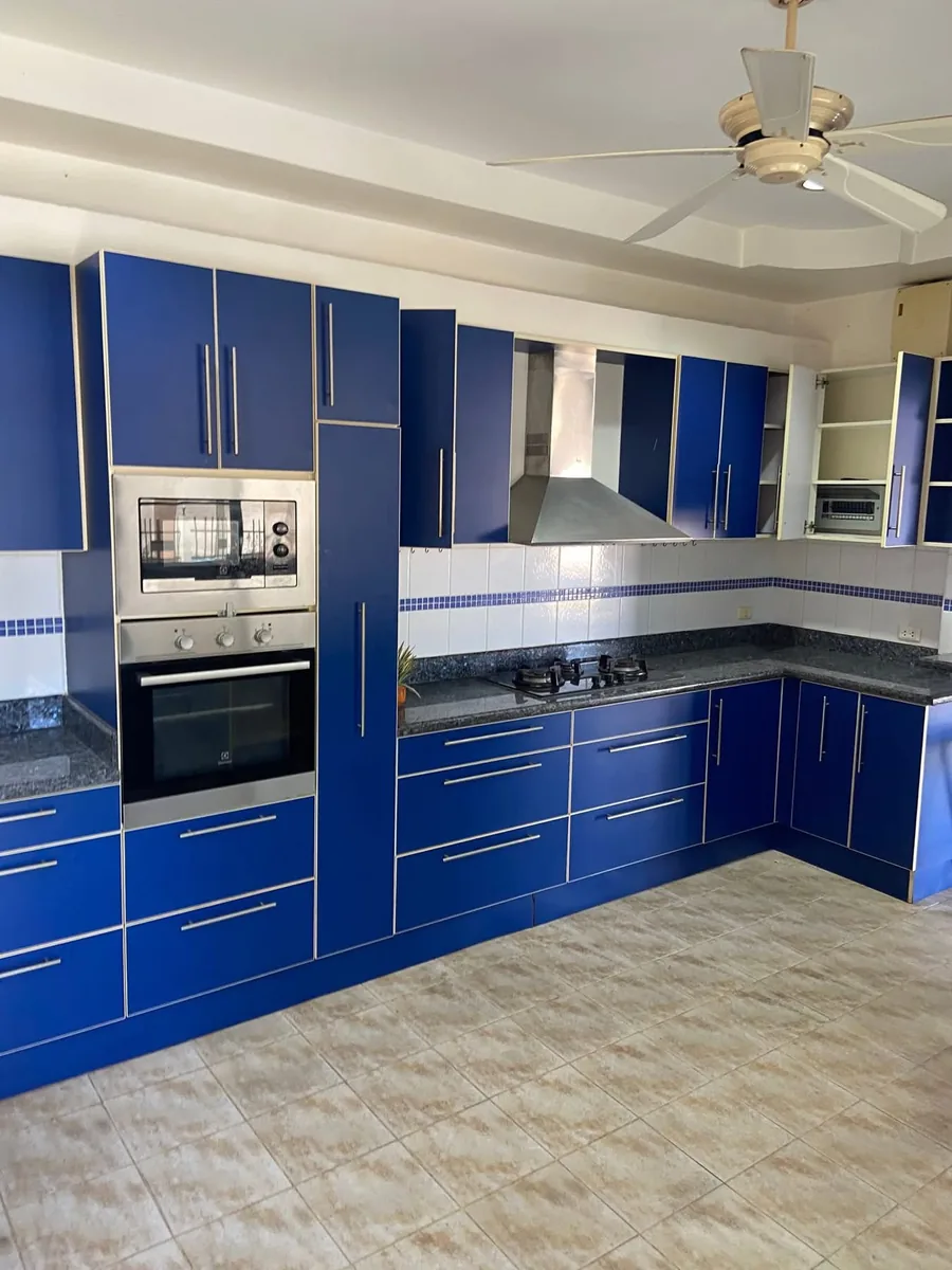 Blue fitted kitchen with granite worktop and built-in oven, by Planet Kitchen in Pattaya